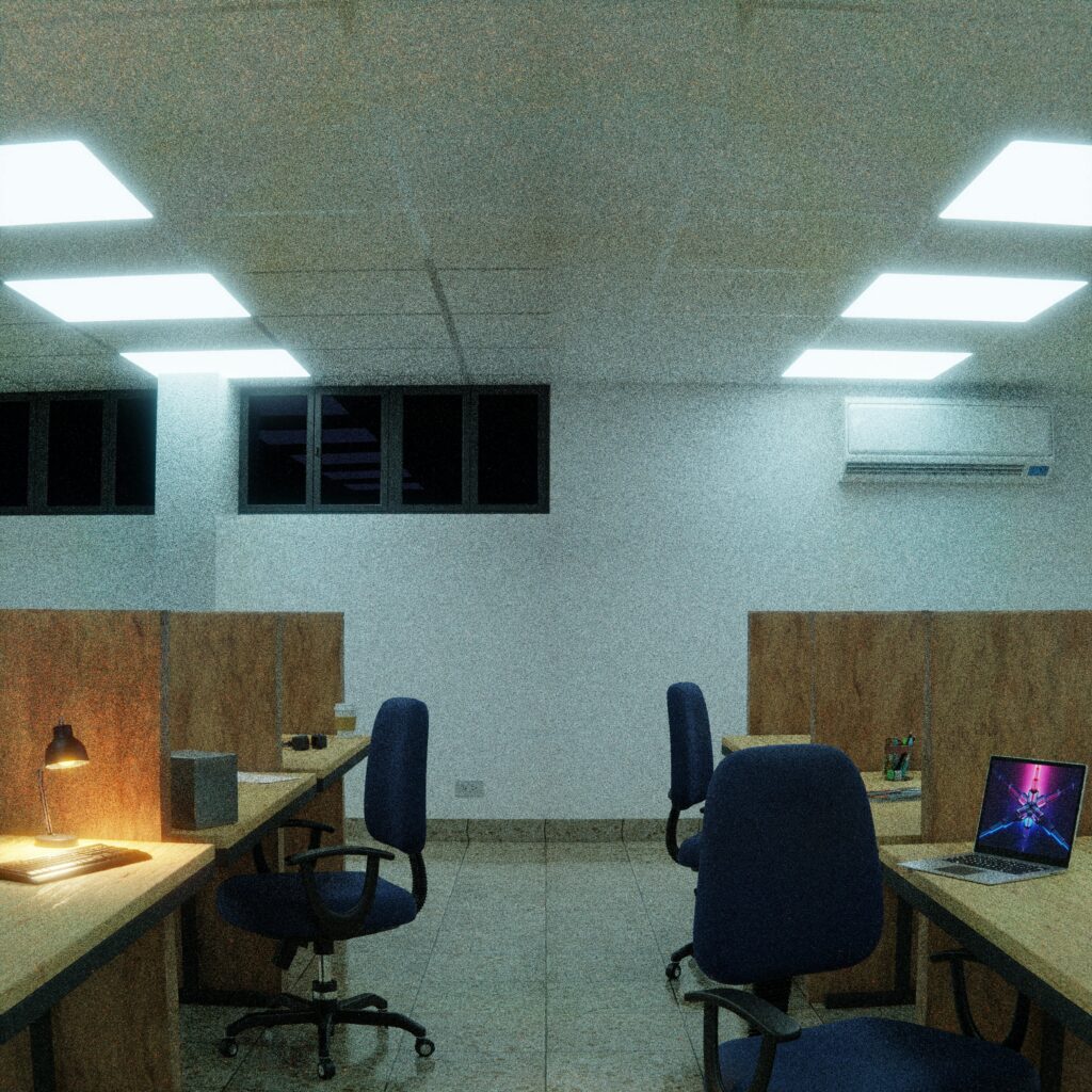 A dimly lit modern office with cubicles and chairs, featuring LED lights.