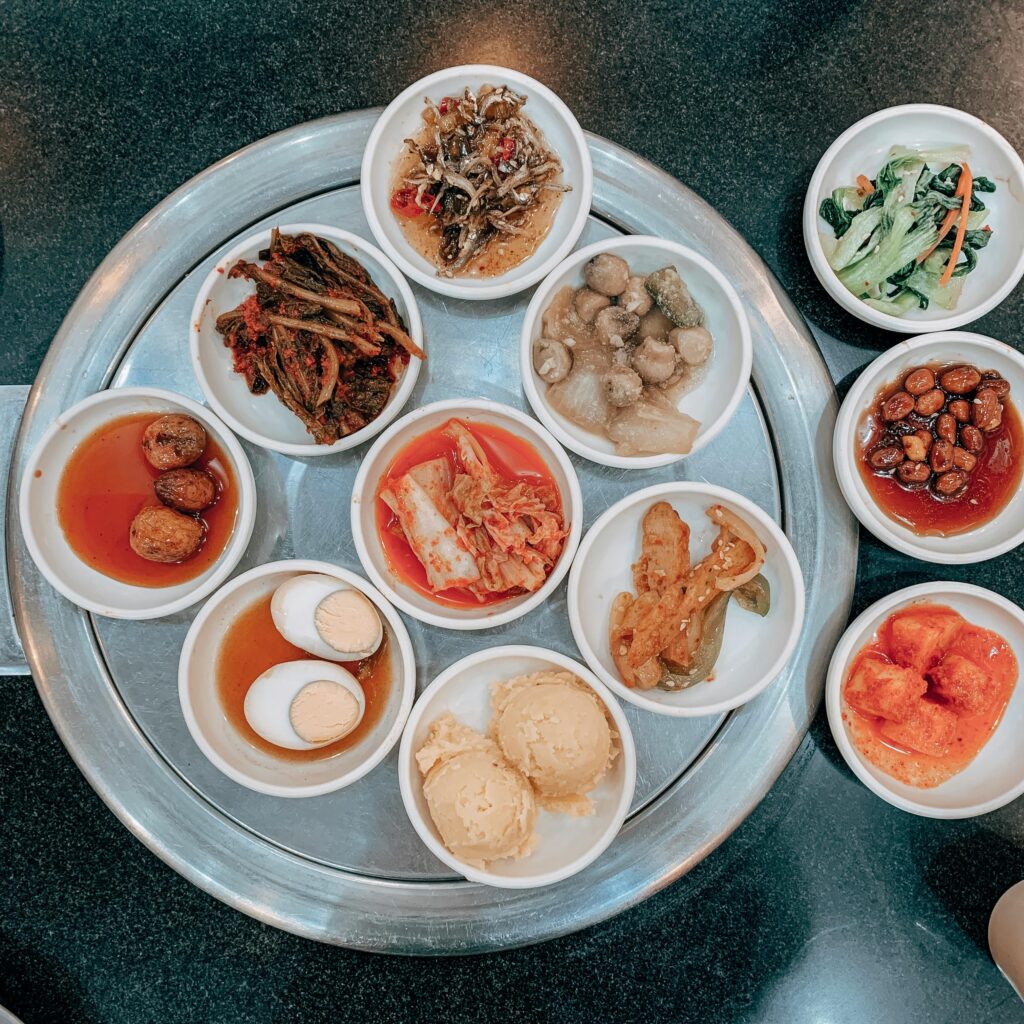 A top view of various traditional Korean side dishes served on a restaurant table, showcasing a flavorful meal.