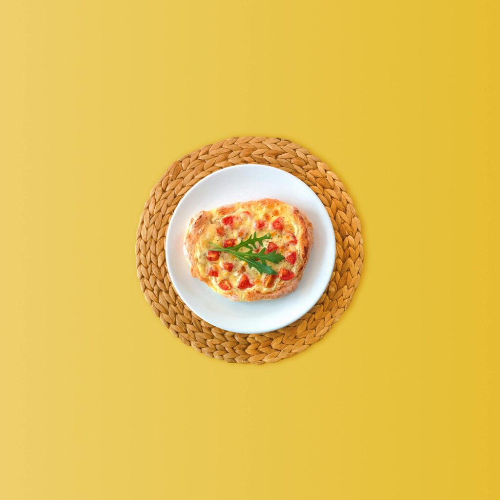 Delicious cheesy bruschetta beautifully presented on a white plate against a yellow backdrop.