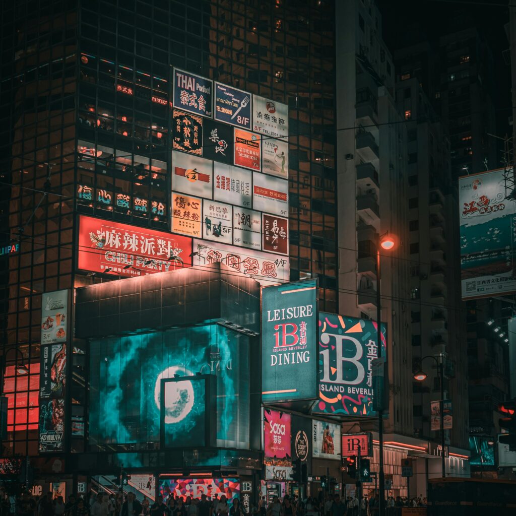 Bright cityscape at night featuring colorful neon signs in an urban environment.